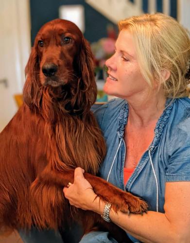 a woman sitting next to a brown dog at Villa Rozenhof in Almen