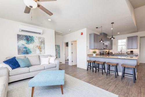 a living room with a white couch and a kitchen at Beach Town Home - Walk to Beaches Downtown Activities and so much more in Half Moon Bay