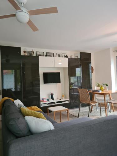 a living room with a gray couch and a table at GREAT CANAL STUDIO - AC, Water view & Free parking in Amsterdam