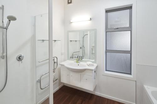 a white bathroom with a sink and a mirror at Lake Watch - Lake Tekapo in Lake Tekapo