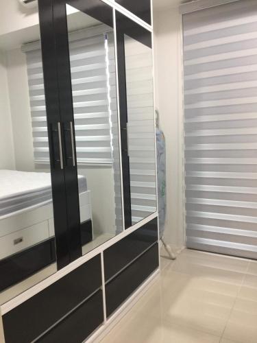 a mirrored dressing room with a mirror and a bed at Sea Residences MoA Manila in Manila