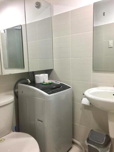 a bathroom with a toilet and a sink at Sea Residences MoA Manila in Manila