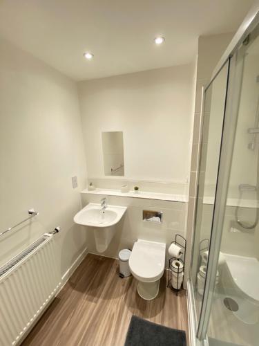 y baño con aseo, lavabo y ducha. en 3 Bedrooms double or single beds, 2 PARKING SPACES! WIFI & Smart TV's, Balcony en Portsmouth