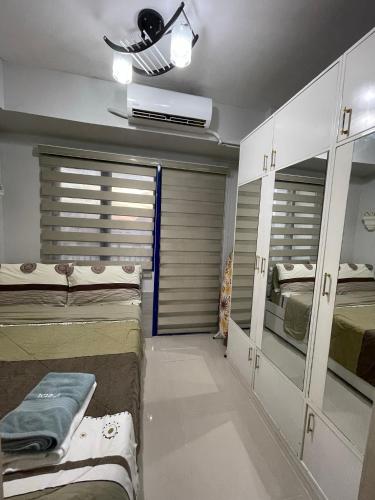 a room with two beds and a room with mirrors at Sea Residences MoA Manila in Manila