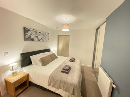 a bedroom with a large bed with a night stand at 3 Bedrooms double or single beds, 2 PARKING SPACES! WIFI & Smart TV's, Balcony in Portsmouth