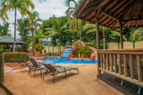 einen Pool in einem Resort mit Stühlen und einer Rutsche in der Unterkunft Bungalows Ballena in Uvita