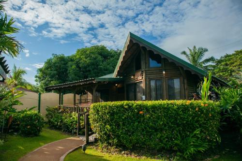 a house with a hedge in front of it at Bungalows Ballena in Uvita