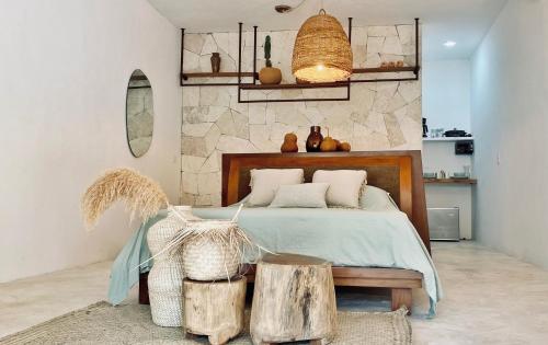een slaapkamer met een bed met een houten hoofdeinde bij Casa Macay in Tulum