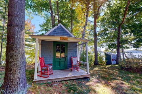 a smallshed with two red chairs and a green door at Saganook in Brunswick