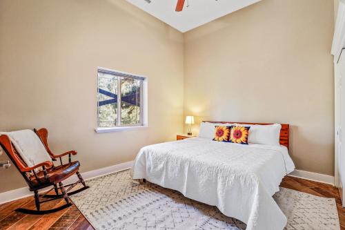 a bedroom with a bed and a chair and a window at Whispering Pines in Flagstaff