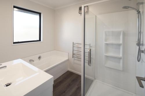 a white bathroom with a sink and a bath tub at Loudon Lodge - Lake Tekapo in Lake Tekapo