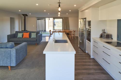 an open kitchen and living room with a couch at Loudon Lodge - Lake Tekapo in Lake Tekapo