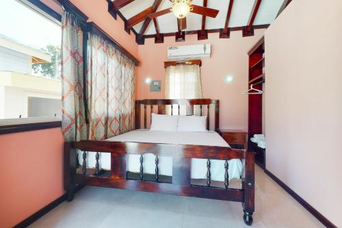 1 dormitorio con cama y ventana en Came at Hummingbird Estate Gold Standard Certified en Dangriga