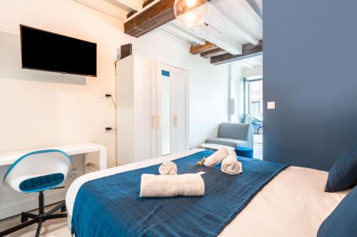 a bedroom with a bed with towels on it at La WAIDE Beau studio centre ville WIFI NETFLIX tout équipé in Amiens