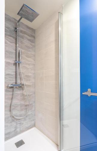 une douche avec pommeau de douche dans une salle de bain dans l'établissement La WAIDE Beau studio centre ville WIFI NETFLIX tout équipé, à Amiens