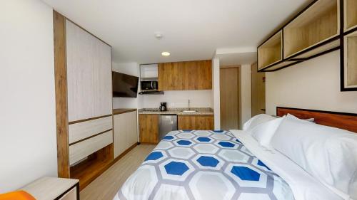 a bedroom with a large bed and a kitchen at Terrazas in Bogotá