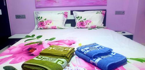 a bed with two towels on it with pink flowers at Perfect Suites in Neos Marmaras