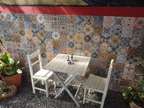 a table and two chairs in front of a tiled wall at Nomada Hostel in Asuncion