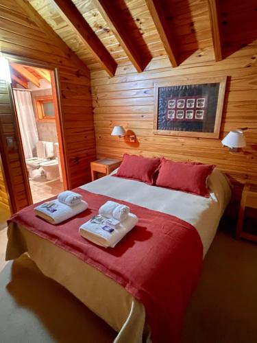 ein Schlafzimmer mit einem Bett mit zwei Handtüchern darauf in der Unterkunft Apart Quillen 1 in San Martín de los Andes