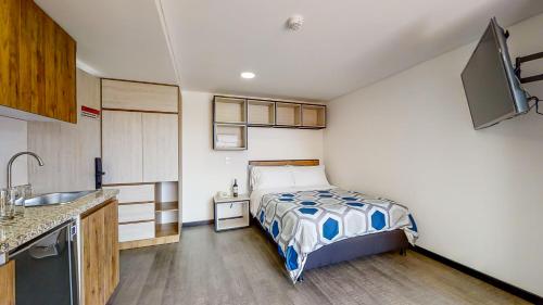 a small bedroom with a bed and a sink at Terrazas in Bogotá