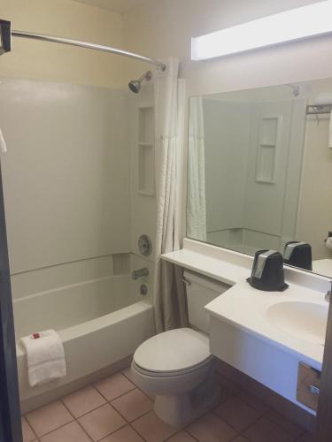a bathroom with a toilet and a tub and a sink at Super 8 by Wyndham Windsor in Windsor