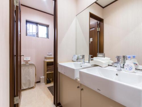 a bathroom with two sinks and a mirror at Woman Only Guesthouse Nanohana (Female only) in Kyoto