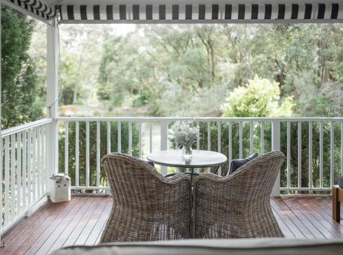 a patio with a table and chairs on a porch at Bells at Killcare Boutique Hotel, Restaurant & Spa in Killcare
