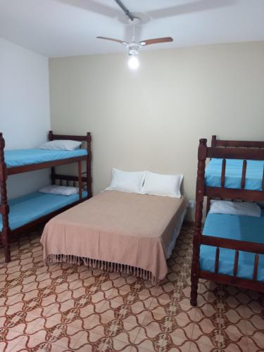 阿拉亚尔-杜卡布Acomodações Araujo的一间卧室配有一张床和两张蓝色双层床