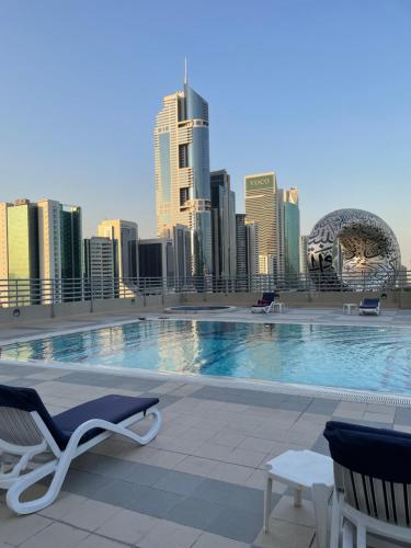 a swimming pool on top of a building with a city skyline at Travelers Backpackers in Dubai