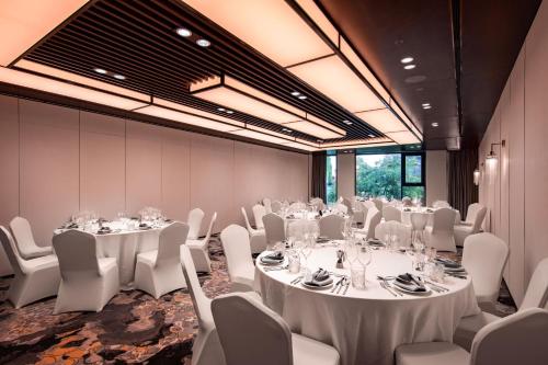 a conference room with white tables and white chairs at The Five Residences Hanoi in Hanoi