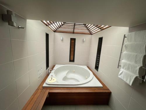 a bath tub in a bathroom with a skylight at Bentleys Motor Inn in Palmerston North