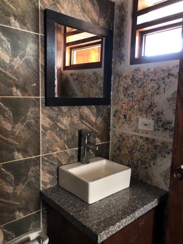 W łazience znajduje się biała umywalka i lustro. w obiekcie Cabañas Duna Campestre w mieście Sáchica