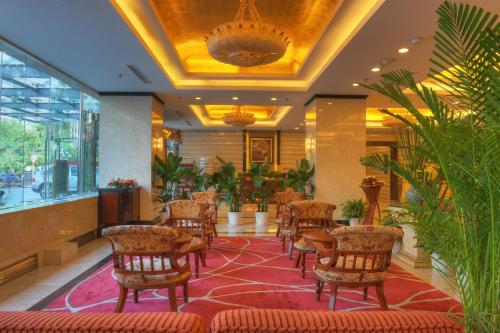 a lobby with chairs and tables and plants at Sunworld Hotel Wangfujing in Beijing