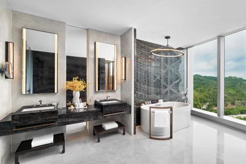 a bathroom with two sinks and a tub and windows at City of Dreams Macau - Nüwa Macau in Macau