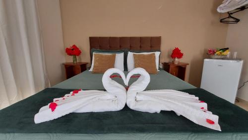 two swansuitsrendered to look like hearts on a bed at Recanto dos Ipês Pousada in Divisa