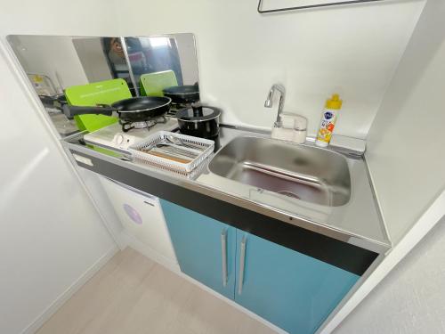 a small kitchen with a sink and a stove at Mr Kintaro Hotel Asakusa South in Tokyo
