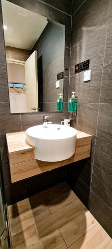 a bathroom with a white sink and a mirror at Qlio Hotel in Kota Kinabalu