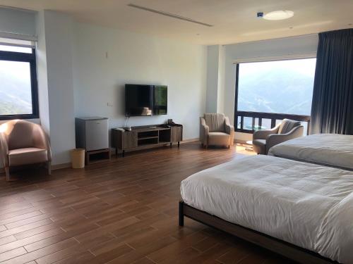 a hotel room with a bed and a flat screen tv at 芸彩莊園 in Renai