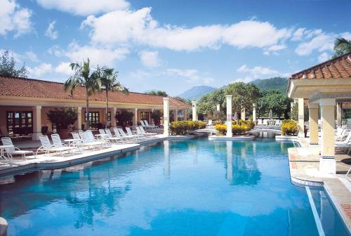 a swimming pool with lounge chairs and a resort at Grand Coloane Resort in Macau