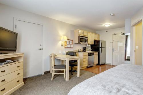 a bedroom with a bed and a table and a kitchen at Candlewood Suites Paducah by IHG in Paducah