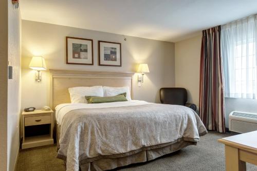 a hotel room with a bed and a chair at Candlewood Suites Paducah by IHG in Paducah