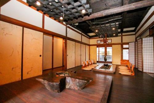 a large room with a couch and chairs in it at Guesthouse Omoya--全個室--囲炉裏のぬくもりと共にグループの絆を深める古民家宿でゆっくりとした時間を-6名部屋-6名部屋-8名部屋--最大20名-ペット同伴可は一室のみ- in Matsuyama