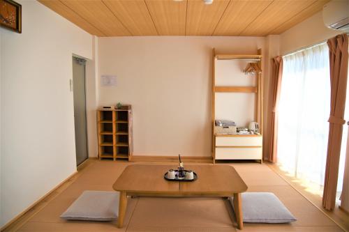 a living room with a coffee table and a window at U-shuku Kyoto Fushimi in Momoyama-chō