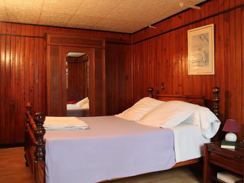 Schlafzimmer mit einem großen Bett mit Holzvertäfelung in der Unterkunft Gîte La Saucelle, 4 pièces, 6 personnes - FR-1-581-57 