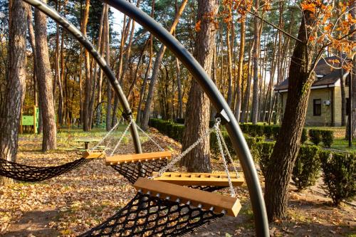 two swings in a park with trees at Kohavi Forest Club in Orlovshchina