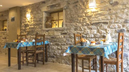 une salle à manger avec deux tables et un mur en pierre dans l'établissement Chambres d'Hôtes 