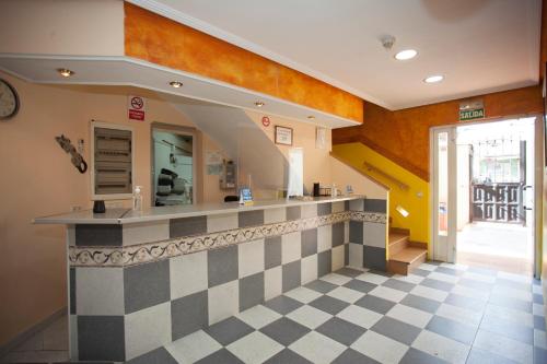 a restaurant with a counter with a checkerboard floor at Hospedaje Los Rosales in Madrid