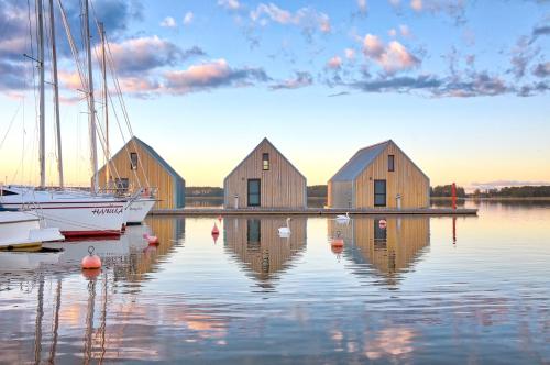 a group of houses on the water with boats at Domy na Wodzie na Mazurach in Pisz