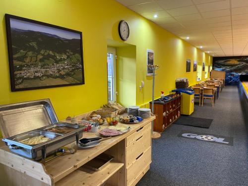 a classroom with yellow walls and a desk with food on it at Relax Centrum Gól in Loučná nad Desnou