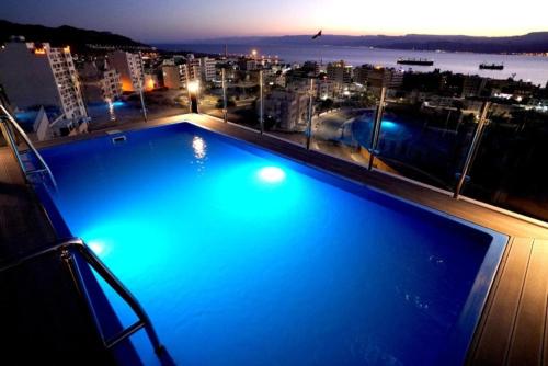 a large swimming pool on top of a building with a city at Baity Boutique Hotel in Aqaba